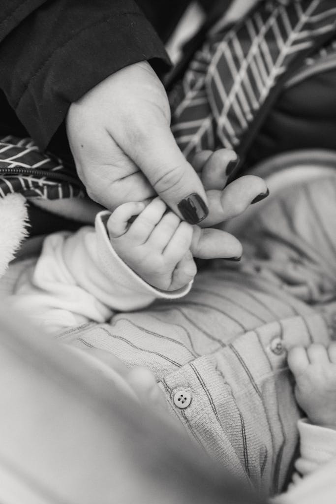 Baby sleeping in bed and holding hand